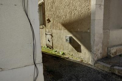 photograph “III.2025” par David Farreny — www.farreny.net — France, Occitanie, Tarn-et-Garonne, Puylaroque, village, maison, house, ruelle, alley, rue, street, bitume, blacktop, asphalte, asphalt, pierre, stone, mur, wall, coin, angle, corner, trottoir, pavement, câbles, cables, fils, wires, fenêtre, window, crépi, roughcast, boîte aux lettres, mailbox, postbox, métal, metal, volets, shutters, numéro, number, 11, ombre, shadow, porte, vieille, door, old, bois, wood