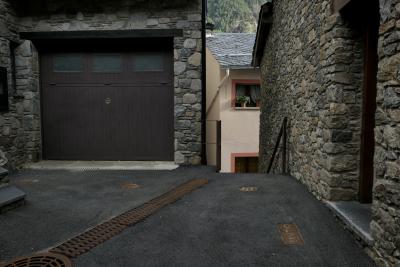 photograph “XI.2022 — Faces of home, 162” par David Farreny — www.farreny.net — Andorre, Andorra, Canillo, bourgade, town, rue, street, ruelle, alley, bitume, blacktop, asphalte, asphalt, maisons, houses, pierre, stone, porte, door, fenêtre, window, garage, portail, gate, marches, steps, escalier, staircase, rampe, banister, fleurs, flowers, pot, gouttière, drainpipe, toit, roof, ardoise, slate, métal, metal, montagne, mountain, forêt, forest, arbres, trees, domicile, home