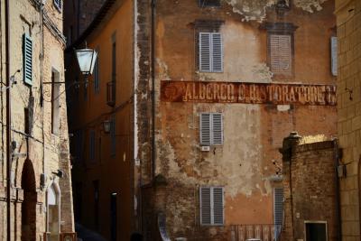 photograph “VIII.2008” par David Farreny — www.farreny.net — Italie, Italia, Italy, Toscane, Toscana, Tuscany, Sienne, Siena, bâtiments, immeubles, buildings, pierre, stone, brique, brick, fenêtres, windows, volets, shutters, bois, wood, lampe, lamp, angle, coin, corner, enseigne, sign, Albergo e ristoratore, vieux, old, architecture