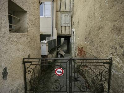 photograph “XII.2024 — Faces of home, 275. Mystery of defense” par David Farreny — www.farreny.net — France, Occitanie, Gascogne, Gascony, Gers, Auch, maisons, houses, allée, alley, passage, entrée, entrance, portillon, métal, gate, metal, panneau, sign, Défense d'entrer, No entry, poignée, handle, murs, walls, beige, crépi, roughcast, fenêtres, windows, volets, shutters, gouttière, drainpipe, clôture, fence, verre, vitre, glass, porte, door, domicile, home