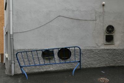 photograph “X.2021” par David Farreny — www.farreny.net — Andorre, Andorra, Canillo, rue, street, mur, wall, crépi, roughcast, câble, cable, fil, wire, gouttière, drainpipe, barrière, barrier, métal, metal, panneaux, signs, bitume, blacktop, asphalte, asphalt, fenêtres, grille, railings, angle, coin, corner, bâtiment, building, immeuble