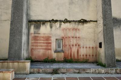 photograph “IV.2025 — I intended to leave a trace” par David Farreny — www.farreny.net — France, Occitanie, Gascogne, Gascony, Lomagne, Tarn-et-Garonne, Beaumont-de-Lomagne, mur, wall, fenêtre, window, étroite, narrow, ciment, cement, béton, concrete, traces, rouge, red, marche, step, vieux, old, boîte à lettres, mailbox, dépression, depression