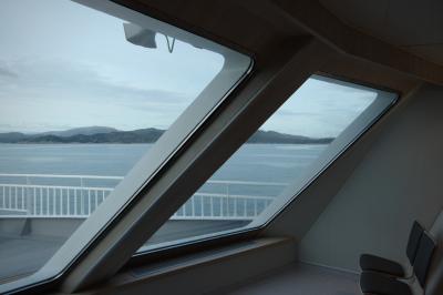 photograph “V.2019 — Run away to the North, 149” par David Farreny — www.farreny.net — Norvège, Norway, Norge, Vestlandet, Hordaland, Bergen, Krokeide, ferry, bateau, boat, bac, Hufthamar, Austevoll, Lysefjord, fjord, mer, sea, eau, water, rivage, shore, collines, hills, montagnes, mountains, baie, fenêtre, window, verre, glass, vitre, haut-parleur, loudspeaker, chaises, chairs, rambarde, guardrail, métal, metal, pont, deck, soir, evening, été, summer, spectacle, show