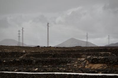 photograph “V.2016” par David Farreny — www.farreny.net — Espagne, España, Spain, Canaries, Canarias, Canary, Lanzarote, Lancerotte, île, island, Arrecife, volcans, volcanoes, montagnes, mountains, paysage, landscape, poteaux, posts, pylônes, pylons, métal, metal, électricité, electricity, fils, wires, câbles, cables, nuages, clouds, pierres, stones, Teguise, Costa Teguise