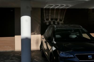 photograph “I.2023” par David Farreny — www.farreny.net — Andorre, Andorra, La Massana, garage, portail, gate, pilier, pillar, voiture, car, Seat, métal, metal, noir, black, reflet, reflection, soleil, sun, béton, concrete