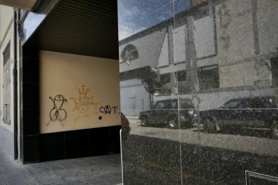 photograph “VIII.2021” par David Farreny — www.farreny.net — Espagne, Spain, España, Catalogne, Cataluña, Catalunya, Lleida, Lérida, Alt Urgell, La Seu d'Urgell, ville, city, rue, street, voitures, cars, mur, wall, garage, entrée, entrance, graffitis, tags, bite, dick, couronne, crown, angle, coin, corner, reflet, reflection, métal, metal, pierre, stone, trottoir, pavement, gouttière, drainpipe, bâtiment, immeuble, building, laid, ugly, laideur, ugliness, sexe, sex, pénis, penis
