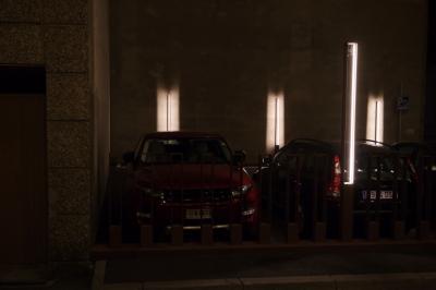 photograph “VIII.2023 — At night” par David Farreny — www.farreny.net — Andorre, Andorra, Canillo, nuit, night, soir, evening, parking, car park, voitures, cars, barrière, rambarde, guardrail, métal, metal, murs, wall, béton, concrete, lumières, lights, éclairage, lighting, néon, neon, tubes, poteaux, posts, poles, garage, portail, gate, coin, angle, corner