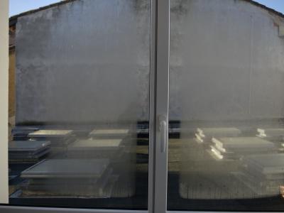 photograph “XII.2016 — Glazing” par David Farreny — www.farreny.net — France, fenêtre, window, verre, vitre, glass, poignée, handle, buée, mist, steam, condensation, toit, roof, mur, wall, ciment, cement, métal, metal, jours, gaps, hiver, winter, matin, morning, encadrement, frame, Occitanie, Gascogne, Gascony, Gers, Auch