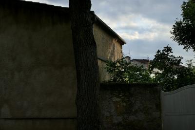 photograph “VI.2020” par David Farreny — www.farreny.net — France, village, maison, house, soir, evening, été, summer, mur, wall, arbre, tree, tronc, trunk, jardin, garden, portail, gate, pierre, stone, bois, wood, tuiles, tiles, gouttière, gutter, drainpipe, métal, metal, nuages, clouds, antenne, antenna, cheminées, chimneys, muret, low wall, feuilles, leaves, feuillage, foliage, Occitanie, Gascogne, Gers, Jegun