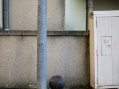 photograph “XI.2014 — Whatever” par David Farreny — www.farreny.net — France, Occitanie, Aveyron, Rouergue, Olemps, béton, concrete, mur, wall, poteau, post, pole, métal, metal, armoire, électrique, electrical, cabinet, plastique, plastic, charnières, hinges, tuyaux, pipes, boule, ball, sphère, sphere, crépi, roughcast