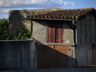 photograph “X.2017” par David Farreny — www.farreny.net — France, Occitanie, Gascogne, Gers, Vic-Fezensac, maison, house, grange, barn, portail, gate, fenêtre, window, volets, shutters, bois, wood, toit, roof, tuiles, tiles, gouttière, gutter, drainpipe, métal, metal, pierre, stone, ciel, sky, automne, fall, autumn, grillage, fencing, arbres, trees, nuages, clouds, rue, street