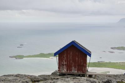 photograph “VII.2017 — Run away to the North, 267. Et visst syn” par David Farreny — www.farreny.net — Norvège, Norway, Norge, Norvège du Nord, Nord-Norge, Nordland, Lofoten, Fredvang, Torsfjorden, mer, sea, eau, water, horizon, montagne, mountain, rocher, rock, nuages, clouds, rivage, seashore, cabane, hytte, hut, bois, wood, rouge, red, bleu, blue, chaînes, chains, panorama, paysage, landscape, marin, seascape, îlots, islets, île, island, carte postale, postcard