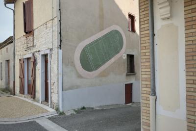 photograph “VII.2022 — Faces of home, 149” par David Farreny — www.farreny.net — France, Occitanie, Tarn-et-Garonne, Cazes-Mondenard, maison, house, ville, city, bourgade, town, rue, street, ruelle, alley, pierre, stone, brique, wall, asphalte, asphalt, bitume, blacktop, gouttière, drainpipe, métal, metal, portes, doors, volets, shutters, bois, wood, fenêtres, windows, génoises, trottoir, pavement, fils, wires, câbles, cables, peinture, painting, illustration, terrain, rugby, field, angle, coin, corner