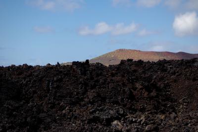 photograph “V.2016 — Lancerotte, 29” par David Farreny — www.farreny.net — Espagne, Spain, España, Canaries, Canary, Canarias, Lanzarote, Lancerotte, île, island, lave, lava, montagne, mountain, volcan, volcano, noir, black, rouge, red, vert, green, ciel, sky, végétation, vegetation, paysage, landscape, nuages, clouds