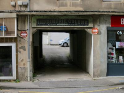 photograph “VI.2013” par David Farreny — www.farreny.net — France, Occitanie, Aveyron, Rouergue, Rodez, rue, street, parking, car park, passage, passageway, voiture, car, panneaux, routiers, signs, roadsigns, magasins, shops, trottoir, pavement, mur, wall, ciment, cement, vitrines, windows, ville, city, tunnel, enseignes, imprimerie, printing house, le web m'a tuer, fils, wires, câbles, cables, gouttière, drainpipe, carrelage, tiling, Colomb