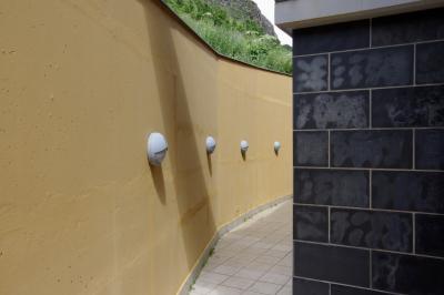 photograph “VI.2021” par David Farreny — www.farreny.net — Andorre, Andorra, Canillo, passage, béton, concrete, bâtiment, immeuble, building, lampes, lamps, ombre, shadow, herbe, grass, montagne, mountain, dallage, paving, jaune, yellow