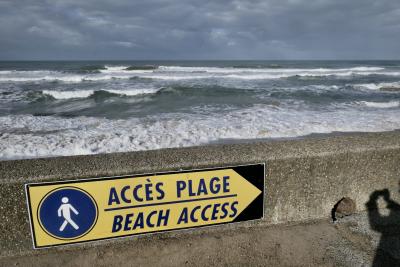 photograph “XII.2020” par David Farreny — www.farreny.net — France, Aquitaine, Pyrénées-Atlantiques, Bidart, Labourd, Pays basque, Basque country, plage, beach, océan, ocean, Atlantique, Atlantic, mer, sea, eau, water, vagues, waves, muret, low wall, panneau, sign, accès plage, beach access, logo, marcheur, walker, flèche, arrow, droite, right, ombre, shadow, photographe, photographer, nuages, clouds