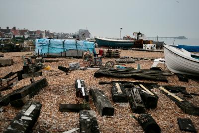 photograph “VII.2010” par David Farreny — www.farreny.net — Royaume-Uni, United Kingdom, Angleterre, England, GB, UK, Deal, Kent, plage, beach, côte, coast, galets, pebbles, shingle, bateaux, boats, Game Bird, bâche, tarpaulin, tarp, traverses, sleeper, ties, bois, wood, noir, black, maisons, houses, Channel, Manche, mer, sea, jetée, embarcadère, pier, paysage, landscape, ce n'est pas un port cependant, not a port though, navires, ships, Cinque Ports