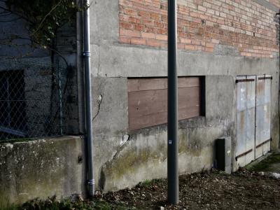 photograph “XII.2024 — Whatever” par David Farreny — www.farreny.net — France, Occitanie, Gascogne, Gascony, Lomagne, Tarn-et-Garonne, Beaumont-de-Lomagne, entrepôt, warehouse, mur, wall, ciment, cement, brique, brick, béton, concrete, portail, gate, bois, wood, window, fenêtre, poteau, post, pole, métal, metal, gouttière, drainpipe, clôture, fence, grillage, fencing, cailloux, stones