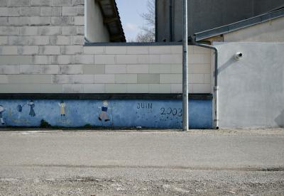 photograph “III.2011” par David Farreny — www.farreny.net — France, bâtiment, building, mur, wall, peinture, painting, fresque, fresco, lampadaire, réverbère, rue, street, lamp, gouttière, drainpipe, béton, concrete, ciment, cement, école, school, personnages, figures, date, juin 2003, June 2003, temps, time, Occitanie, Aveyron, Rouergue, Olemps