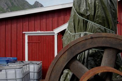 photograph “VII.2017 — Run away to the North, 114” par David Farreny — www.farreny.net — Norvège, Norway, Norge, Norvège du Nord, Nordland, Flakstad, Sund, maison, house, bois, wood, rouge, red, Falun, roue, wheel, métal, metal, rouille, rust, rusty, bâche, cover, tarpaulin, plastique, plastic, tarp, citernes, cuves, cisterns, tanks, poubelle, bin, trash, garbage, can, montagne, mountain, pic, peak, sommet, summit, top, corde, rope, porte, door, Arctique, Arctic