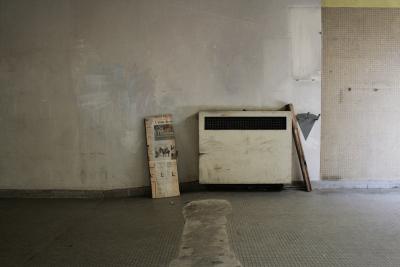 photograph “IV.2013” par David Farreny — www.farreny.net — France, Occitanie, Aveyron, Rouergue, Rodez, garage, mur, wall, paroi, béton, concrete, carrelage, tile, radiateur, radiator, heater, métal, metal, planche, plank, bois, wood, journal, newspaper, Midi Libre, cheval, horse