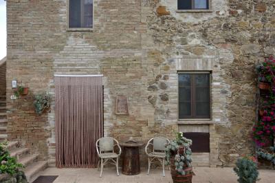 photograph “VIII.2022 — Faces of home, 169” par David Farreny — www.farreny.net — Italie, Italia, Italy, Toscane, Toscana, Tuscany, Sienne, Siena, San Quirico d'Orcia, maison, house, façade, facade, pierre, stone, brique, brick, beige, porte, door, fenêtres, windows, escalier, stairs, staircase, marches, steps, rideau, curtain, chaises, chairs, table, tonneau, barrel, plantes, plants, fleurs, flowers, pots, panneau, sign, vendita diretta olio e vino, été, summer, domicile, home