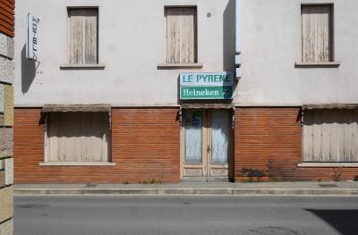 photograph “IV.2024 — Whatever” par David Farreny — www.farreny.net — France, Occitanie, Tarn-et-Garonne, Caussade, bâtiment, immeuble, building, rue, street, bitume, blacktop, asphalte, asphalt, trottoir, pavement, béton, concrete, brique, brick, pierre, stone, hôtel, fermé, hotel, closed down, fenêtres, windows, bar, restaurant, enseigne, sign, Le Pyrène, Heineken, porte, door, ombre, shadow