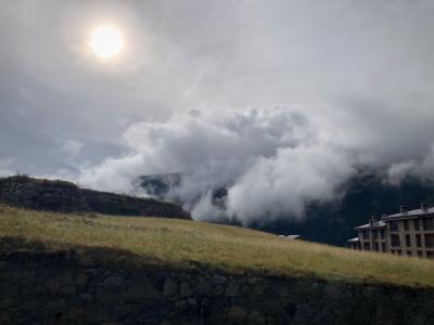 photograph “X.2021 — Announcement” par David Farreny — www.farreny.net — Andorre, Andorra, Canillo, Pyrénées, Pyrenees, montagne, mountain, prairie, meadow, pré, pasture, herbe, grass, automne, autumn, fall, nuages, clouds, soleil, sun, bâtiment, immeuble, building, fenêtres, windows, ciel, sky, gris, grey, gray, murat, low wall, pierre, stone