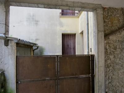 photograph “VI.2013 — Faces of home, 73” par David Farreny — www.farreny.net — France, domicile, home, ciment, cement, pierre, stone, garage, portail, gate, métal, metal, rouille, rust, rusty, fenêtres, windows, volets, shutters, mur, wall, poignée, handle, tôle ondulée, corrugated iron, gouttière, gutter, drainpipe, maison, house, Occitanie, Rouergue, Aveyron, Rodez