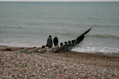 photograph “V.2013 — Disappointment” par David Farreny — www.farreny.net — Royaume-Uni, United Kingdom, Grande-Bretagne, Great Britain, Angleterre, England, UK, GB, Sussex, West Sussex, Arun, Bognor Regis, front de mer, seafront, mer, sea, Manche, Channel, horizon, épi, groyne, brise-lames, breakwater, eau, water, bois, wood, cailloux, stones, galets, pebbles, shingle, rivage, shore, pierre, stone, promeneurs, walkers, couple, homme, man, femme, woman, panier, basket, interruption, break, personnages, figures, enfant, child